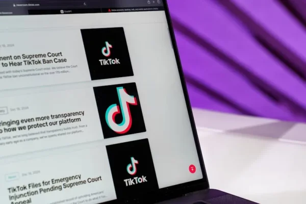 Close-up of laptop screen showing TikTok news articles with a purple background.