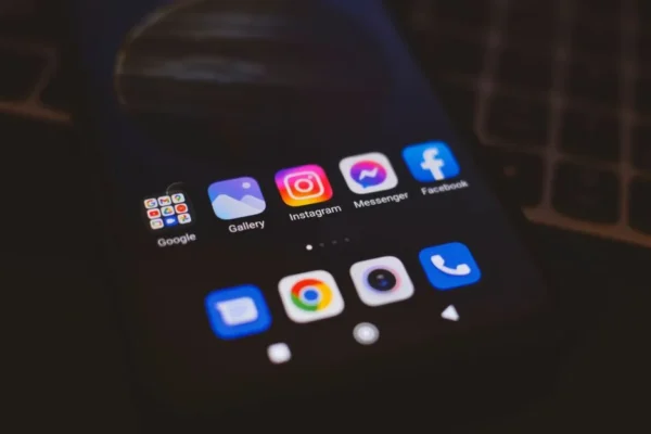 A smartphone displaying popular social media apps in a dimly lit environment, perfect for tech and communication themes.