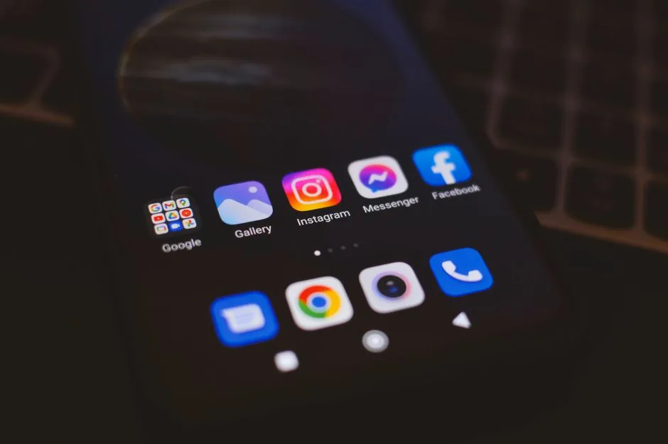 A smartphone displaying popular social media apps in a dimly lit environment, perfect for tech and communication themes.
